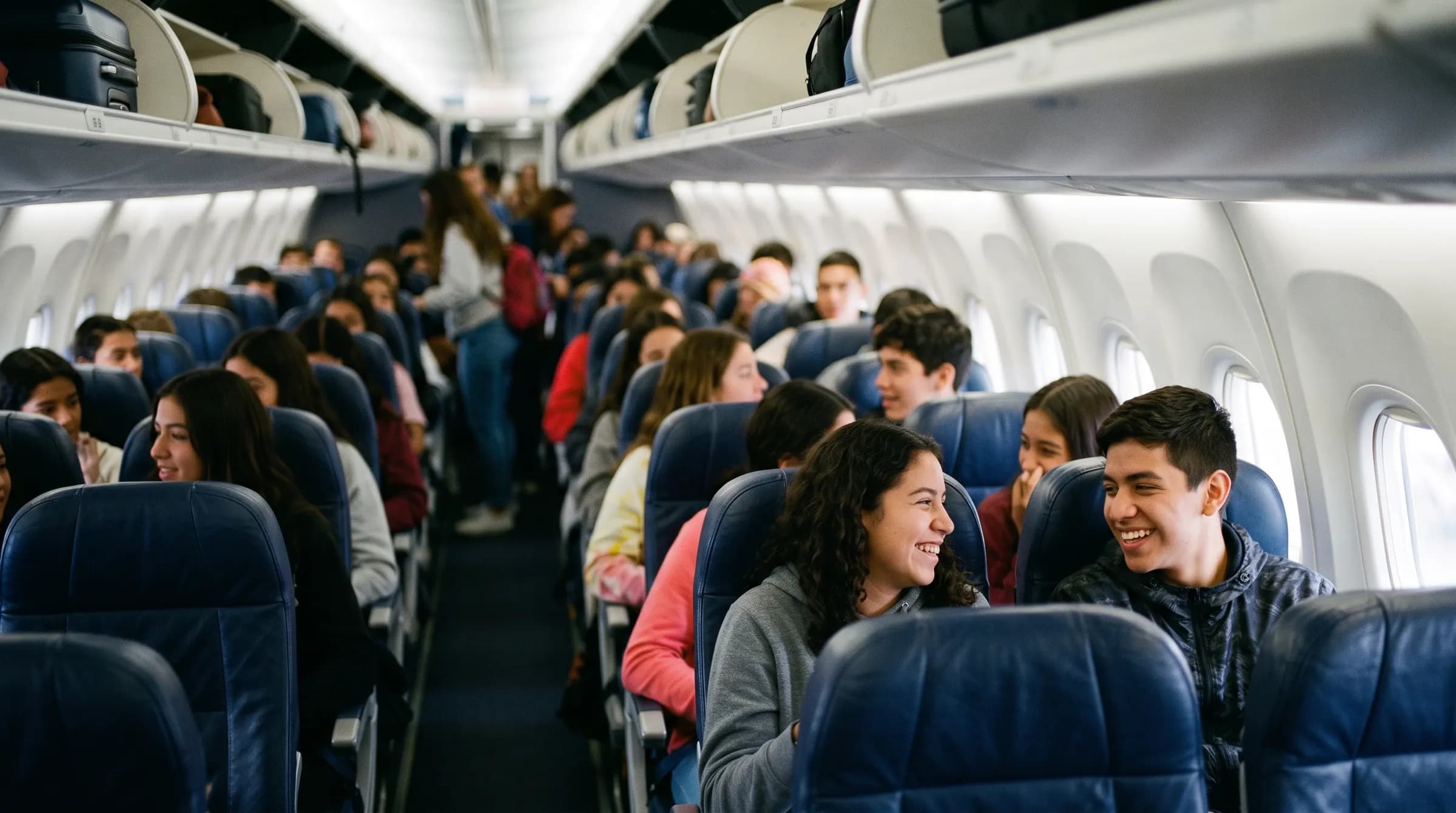 Estudiantes riendose en la cabina de un avion lleno